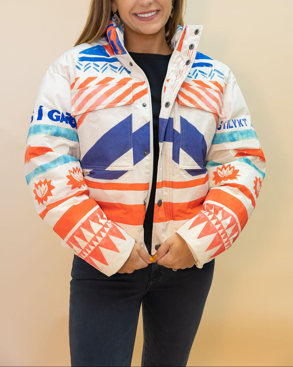 Woman wearing a colorful jacket with geometric patterns on a beige background