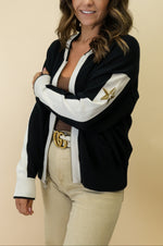 Woman wearing a black and white jacket with a star design on a beige background