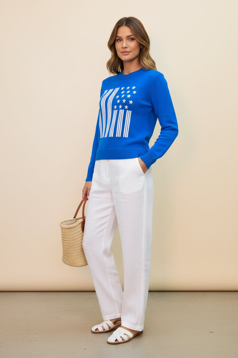Blue sweater with American flag design worn by a person on a beige background